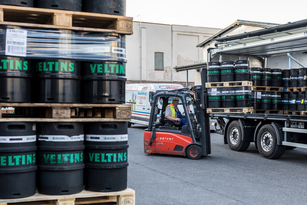 Stapler belädt einen Lkw mit Bierfässern